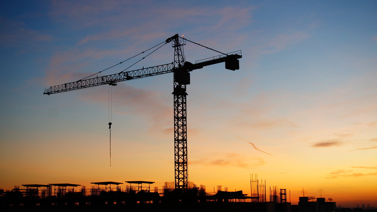 Construction cranes with sunset